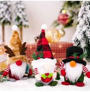 Detailed close-up of three Christmas gnomes with plaid hats and antlers on snow