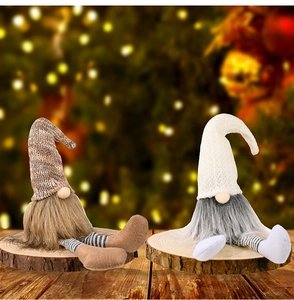 Due gnomi natalizi con gambe a strisce su basi di legno e calde luci festive soffuse