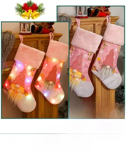 Detailed view of pink plush Christmas stockings with sequins and glowing LED light effect