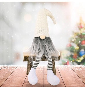 Dettaglio di gnomo natalizio con cappello bianco a maglia e lunghe gambe a righe su panca