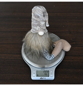 Dettaglio di uno gnomo natalizio nordico con cappello di maglia grigio e gambe a strisce