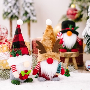 Three Christmas gnomes with plaid hat and reindeer antlers on a snowy background