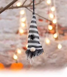 Detail of Halloween gnome hanging ornament with striped hat and spider on a branch