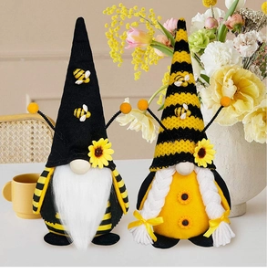 Dettaglio di gnomi ape con accenti di girasole e cappelli a maglia su un tavolo