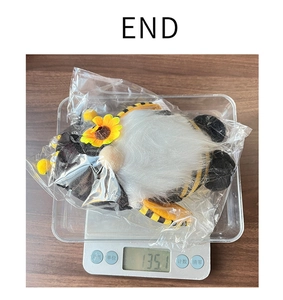 Gnomo di peluche a tema ape pesato su una bilancia digitale elettronica di precisione