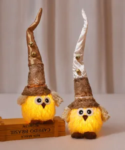 Close-up of glowing plush owl figurine with snowflake hat and warm yellow LED light