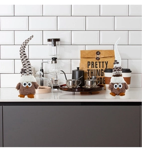 Macro detail of plush owl dolls with checkered and white hats in a cozy cafe setting