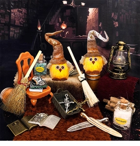 Dettaglio del gufo di peluche luminoso con scopa magica e boccette di cristalli curativi