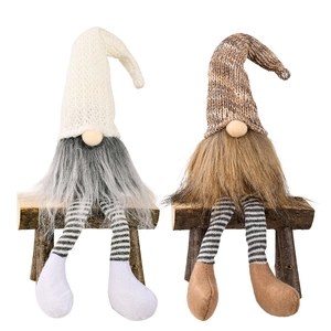 Coppia di gnomi natalizi nordici con lunghe gambe a righe su panca in legno decorativa