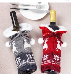 Close-up of knitted Christmas wine bottle covers with reindeer and snowflake patterns
