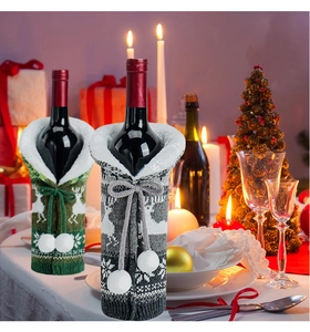 Close-up of knit Christmas wine bottle covers with reindeer patterns and white fur trim