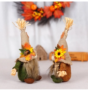 Close-up of harvest gnomes with burlap hats, sunflowers and maple leaves for autumn decor