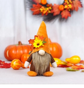 Detalle de gnomo otoñal con gorro de fieltro naranja y decoración de hojas de arce