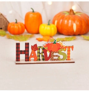 Close-up of wooden Harvest sign with pumpkin and maple leaf patterns on a rustic table