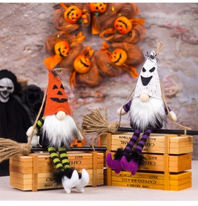 Detail view of Halloween gnome figurines with witch hats and brooms on a wooden box