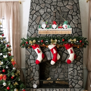 Wooden Christmas gnome advent calendar with 24-day countdown hanging over a cozy fireplace