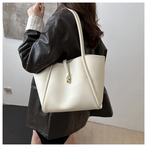Borsa tote beige minimalista con pieghe laterali e chiusura dorata sulla tracolla
