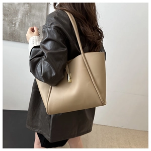 Dettaglio della borsa tote in ecopelle beige con fibbia in metallo dorato sulla spalla