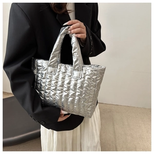 Close-up of metallic silver quilted down handbag showing soft texture and puffy design