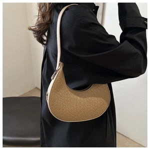 Detailed view of beige croco-embossed texture on a crescent hobo shoulder bag