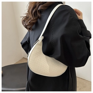 Detailed view of white woven crescent shoulder bag on model with silver metal zipper