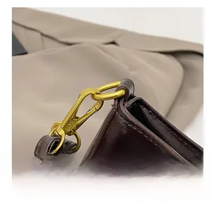 Detailed close-up of premium gold-tone hardware and leather strap on a crescent bag