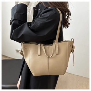 Détail du sac cabas kaki en cuir grainé avec doubles bretelles et nœuds décoratifs sur le côté