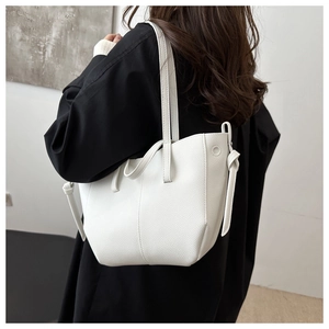 Detail of white lychee leather tote bag with dual straps shown on model from back view