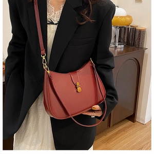 Deep burgundy crescent shoulder bag styled with a black blazer for a chic autumn look