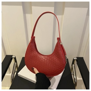 Detail of red croc-embossed hobo bag showing texture and metal buckle on side strap