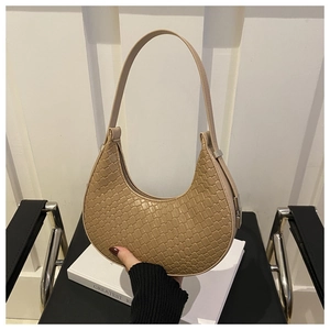 Close-up of latte woven crescent bag with slim shoulder strap and smooth PU texture