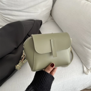 Elegant sage green semi-circular leather crossbody bag with gold zipper and strap