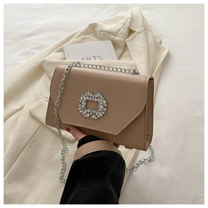 Detail of beige chain shoulder bag featuring V-shaped flap and crystal square buckle
