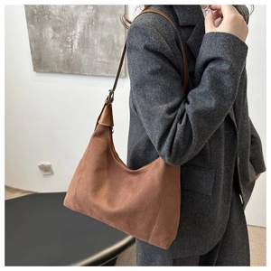 Brown faux suede crescent bag on shoulder with dark grey wool blazer outfit