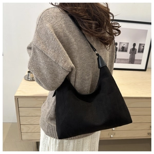 Close-up of minimalist black matte hobo bag shoulder strap and curved structure