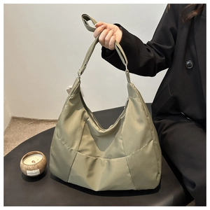 Macro detail of padded crescent tote bag in olive green with silk luster and adjustable strap