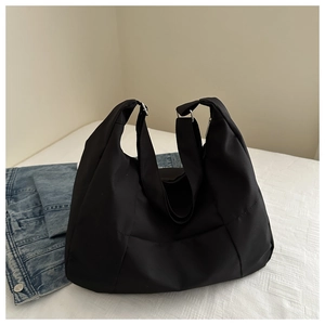 Detail of black large capacity hobo bag with wide shoulder strap and silver buckle adjustment
