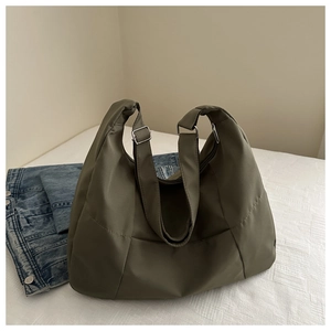 Detailed view of olive green nylon tote bag featuring adjustable strap and silver metal buckle