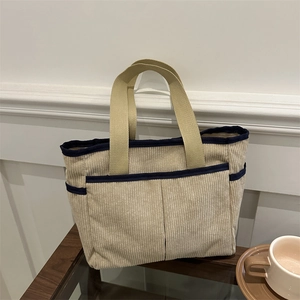 Minimalist beige corduroy tote bag with blue trim and dual front pockets for women