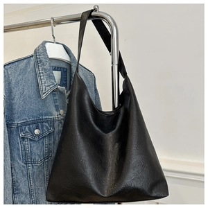 Detailed close-up of the vintage black faux leather texture on the large hobo tote bag