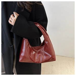 Close-up of burgundy glossy leather hobo bag texture with high mirror finish shine