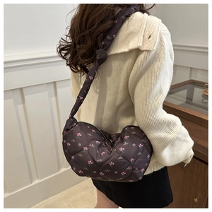Detail of brown quilted floral dumpling bag showing the soft texture and knotted handle