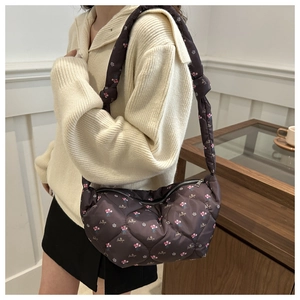 Close-up of dark brown quilted floral dumpling bag with comfortable wide shoulder strap