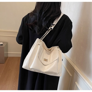 Détail d'un grand cabas blanc avec bandoulière chaîne porté par un mannequin pour le travail