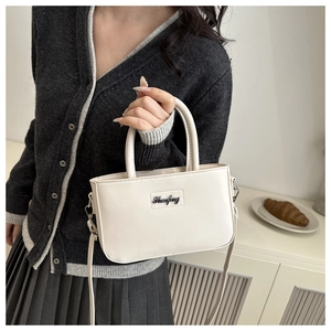 Chic cream leather handbag shown in a French lifestyle setting with soft indoor lighting