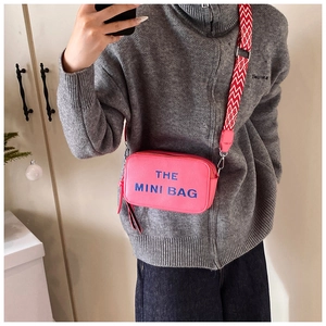 Pink pebbled leather mini crossbody bag with blue embroidery and geometric wide strap