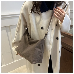 Deep brown matte suede tote bag shown on a model with minimalist white background