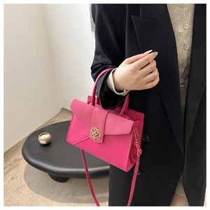 Detailed view of magenta tote bag with gold rose clasp and minimalist leather texture