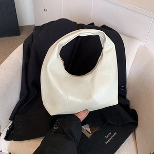 Chic off-white leather hobo bag with unique patchwork texture in a minimalist style