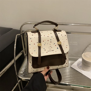 Retro polka dot backpack with leather trim on a display shelf for stylish lifestyle